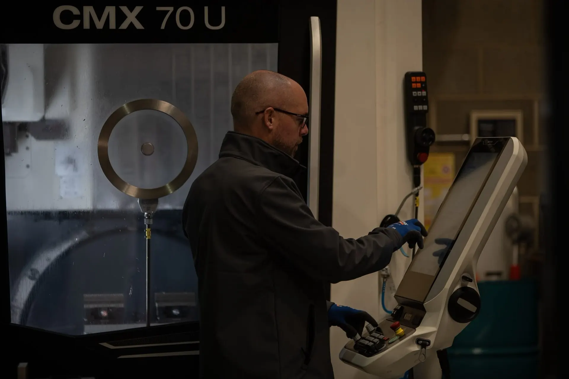 Engineer operating a DMG MORI CMX 70 U 5-axis CNC machine in Chatteris, Cambridgeshire